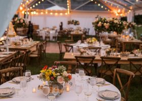 CLEAR STRUCTURE TENT WITH SWAGGED BISTRO LIGHTS AND WALL DRAPING